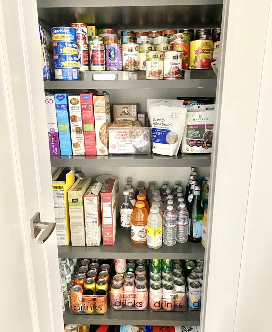 A pantry with many different foods and drinks.